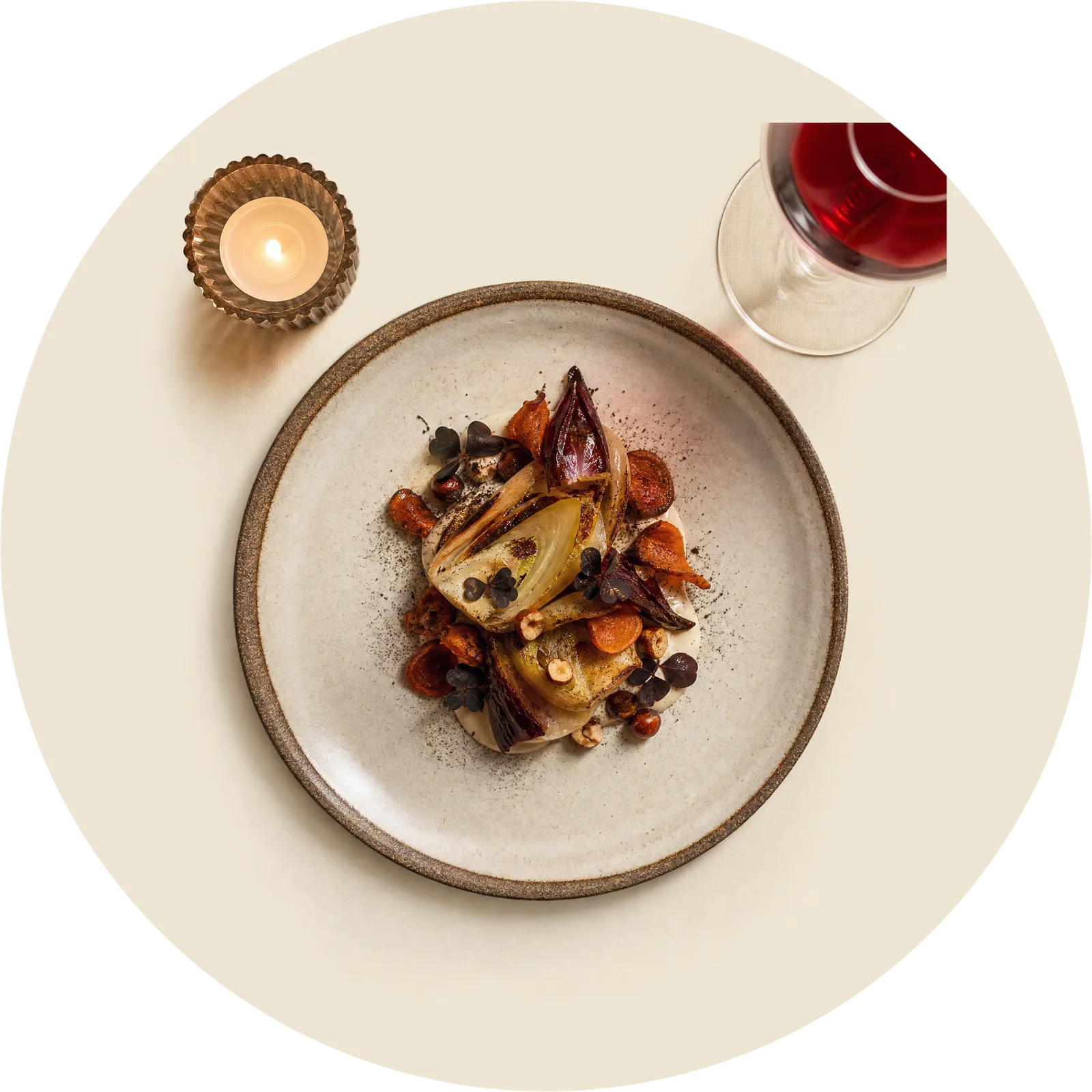 A plated seasonal course on white linen under warm candlelight, seen from above